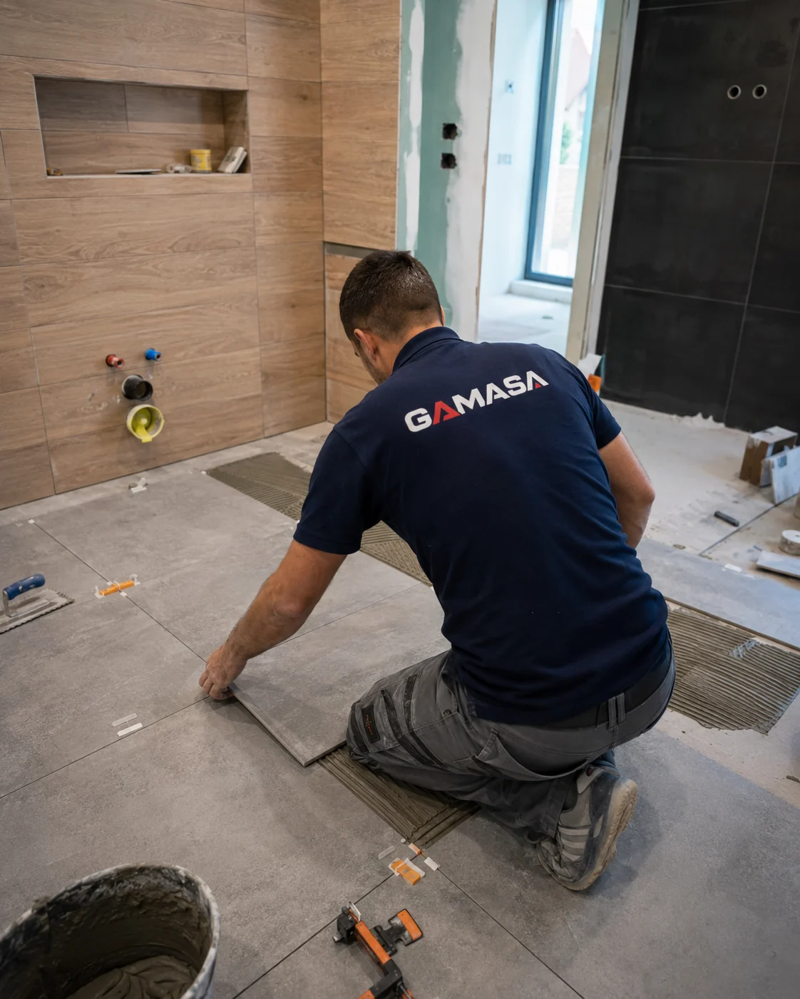 Alicatador de GAMASA colocando baldosas de gran formato en baño
